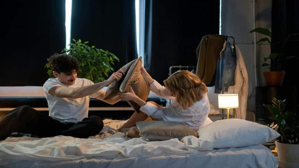 A couple having a pillow fight 