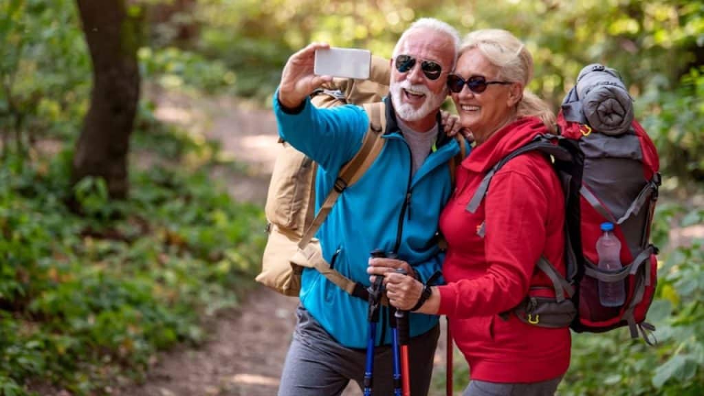 A happy couple taking selfie while hiking in the forest