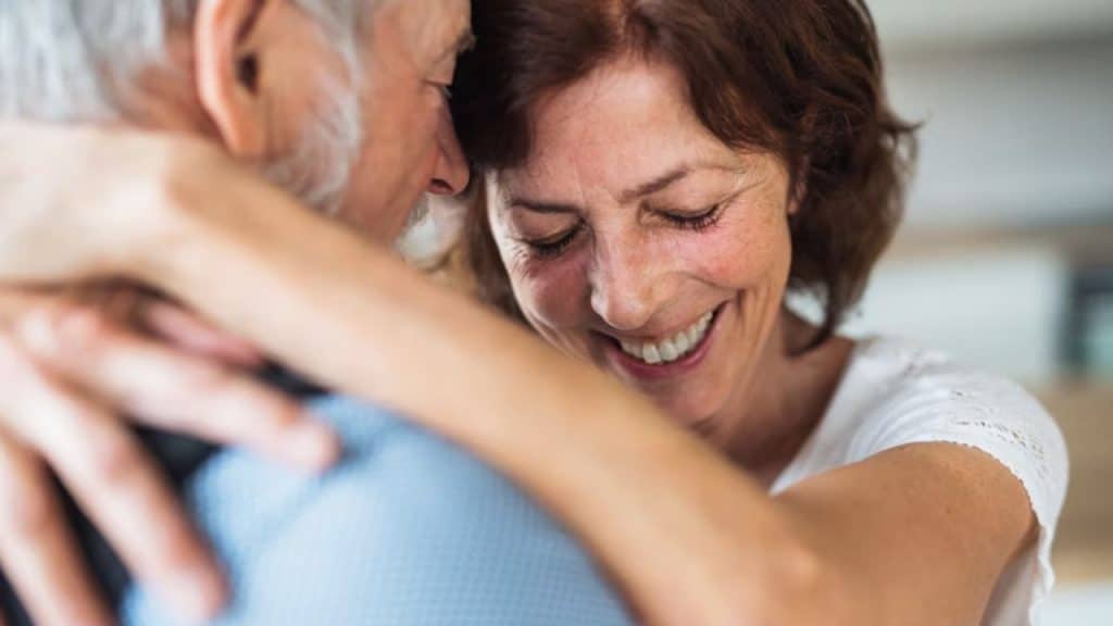 A couple laughing together while dancing in the living room