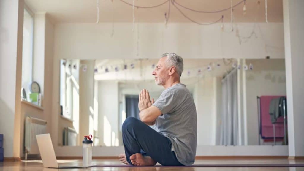 A man practicing meditation at home