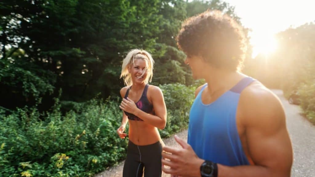 A woman cheering on her partner during their morning jog in the park.