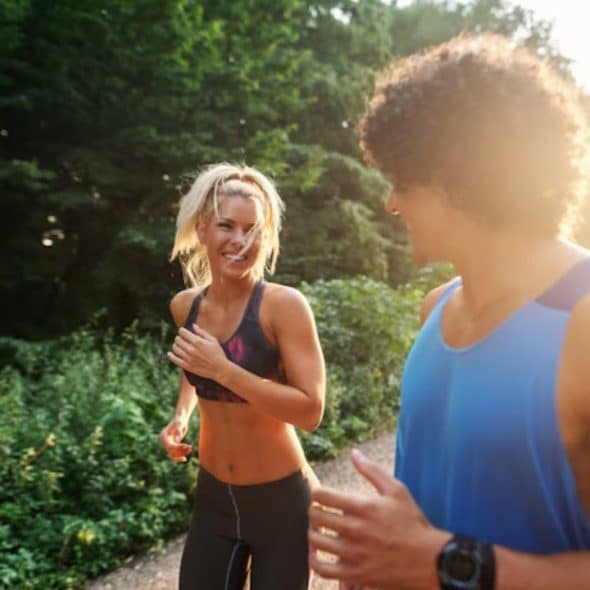 A woman cheering on her partner during their morning jog in the park.