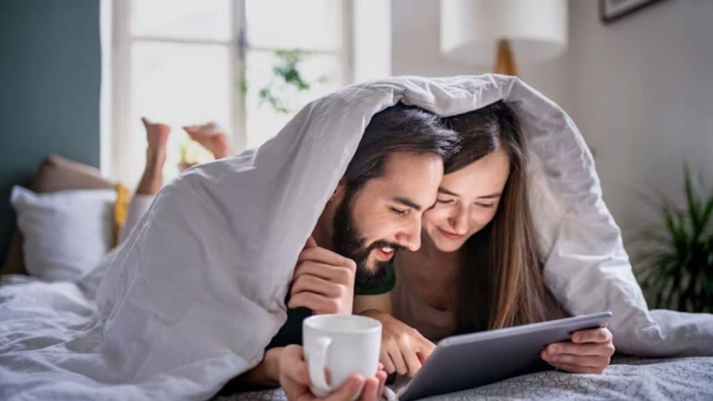 Couple reading before bed with warm bedside lighting