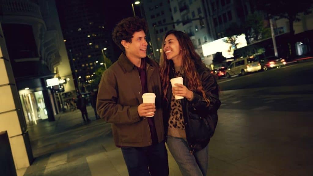 Couple discussing future plans while walking with coffee