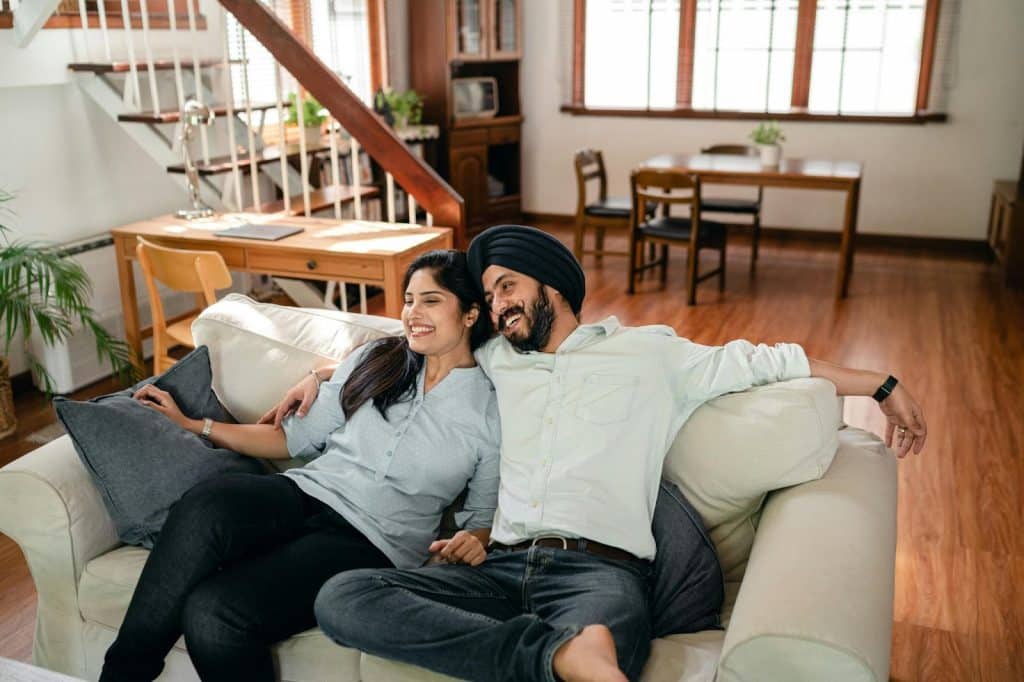A man and woman at home sitting at the couch