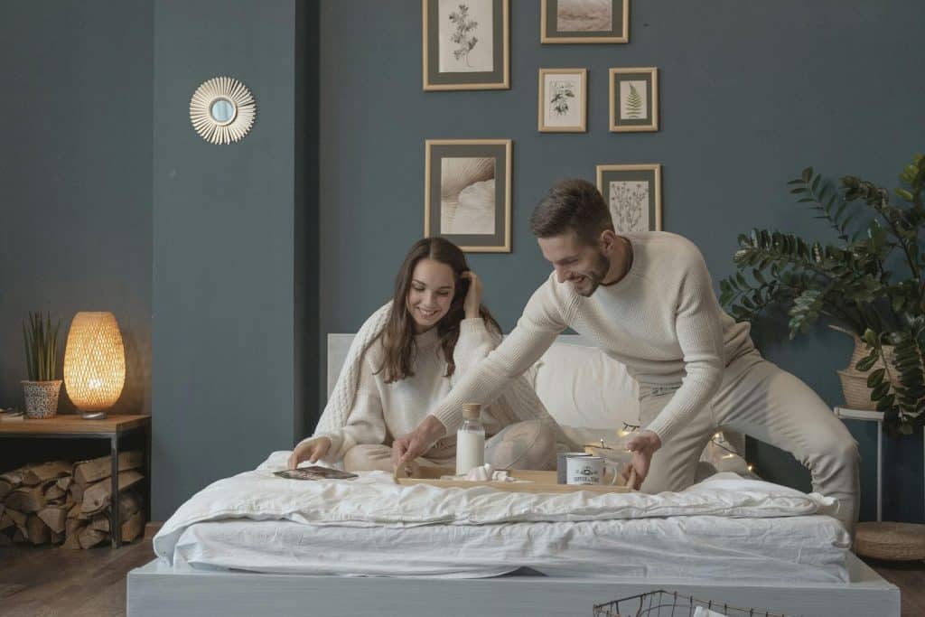 A man and woman having a breakfast in bed