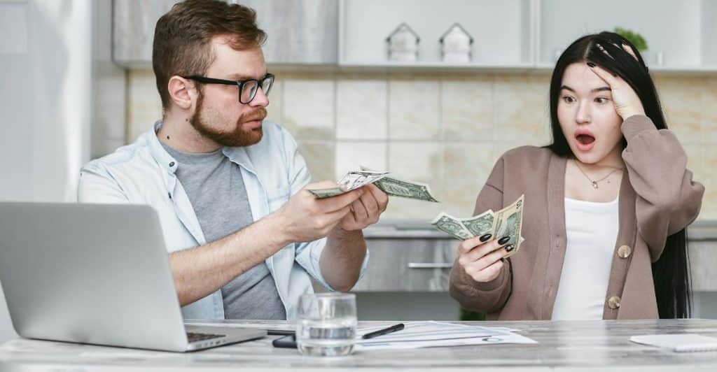 Couple talking and holding money