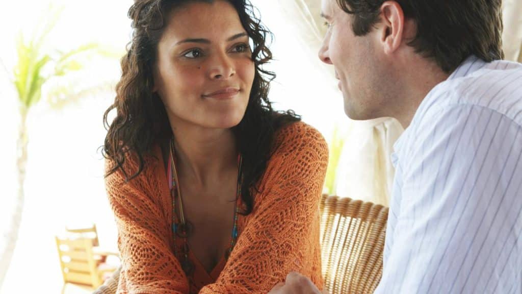 A woman and a man sitting closely, engaged in conversation.