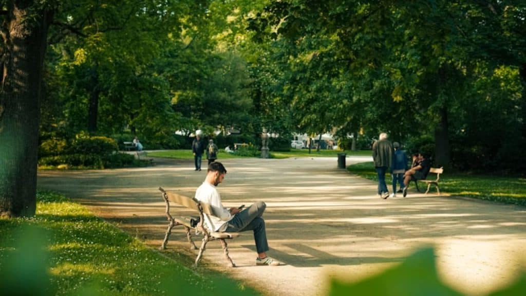 Man waiting calmly on a park bench