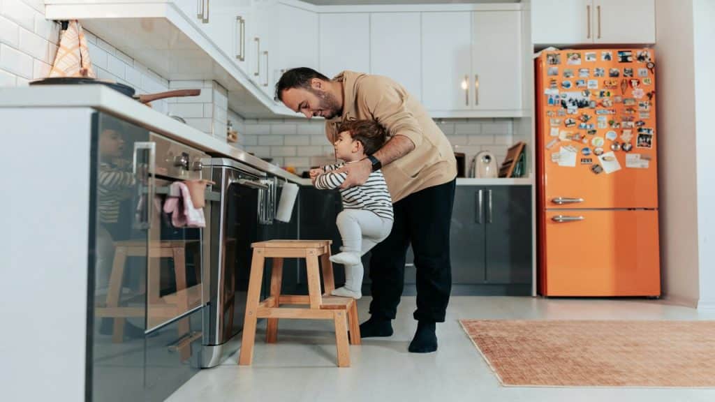 A man helping his baby wash his hands