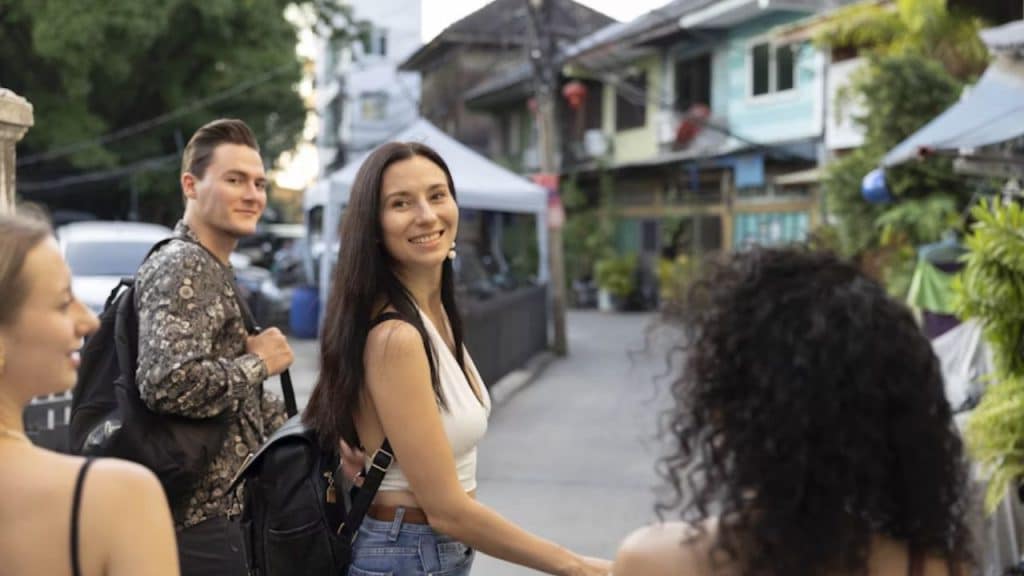 Couple talking while women in the background passes by