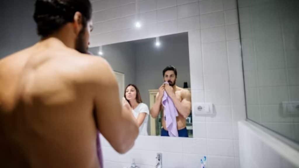 Man getting ready in the morning while woman notices his routine