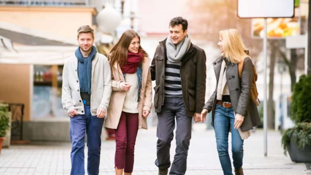 Man greeting another man confidently while woman observes