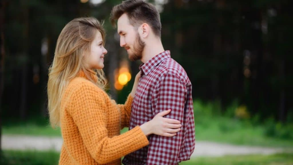 Man arriving on time to meet a woman, both smiling