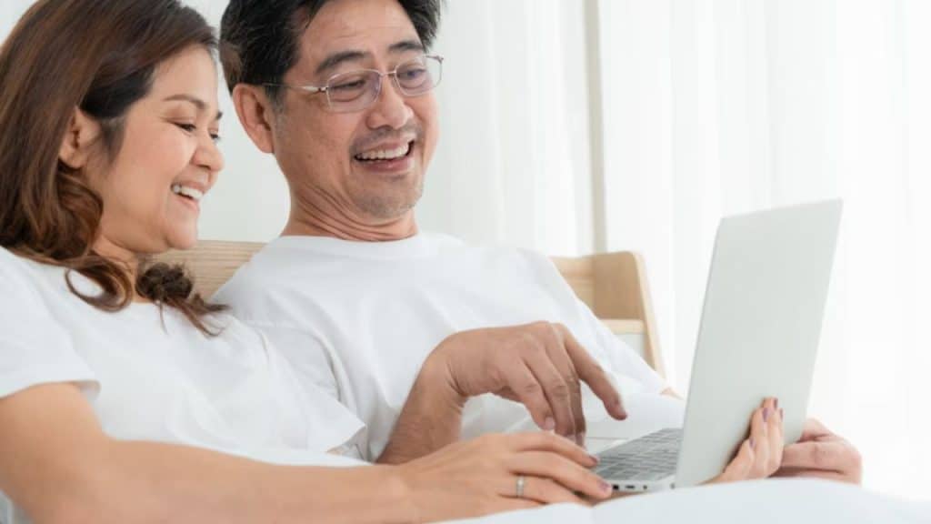 Man closing laptop while woman smiles at him
