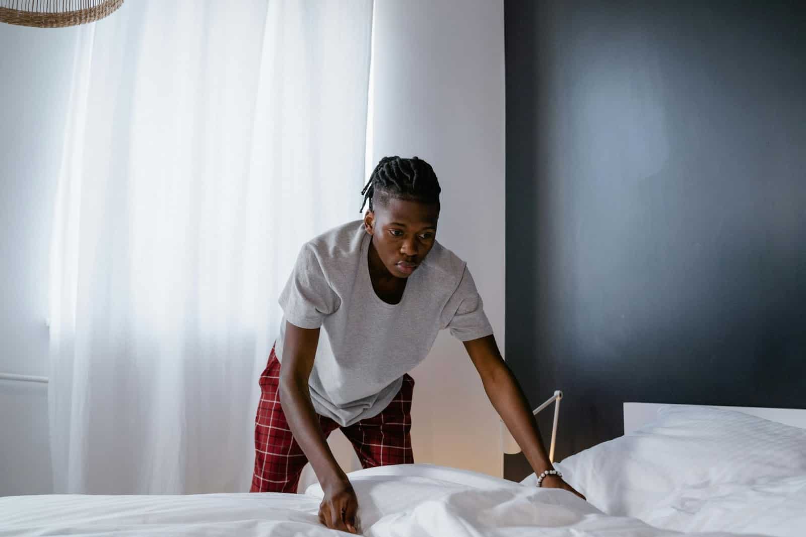 A man fixing a bed.