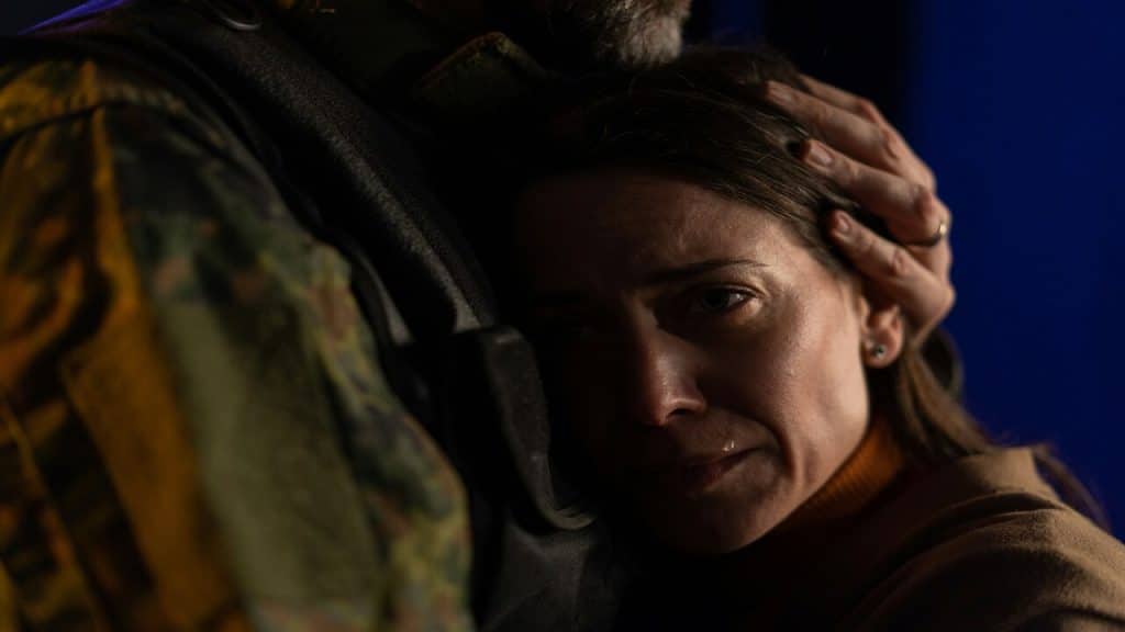 A woman crying while her husband hugs her