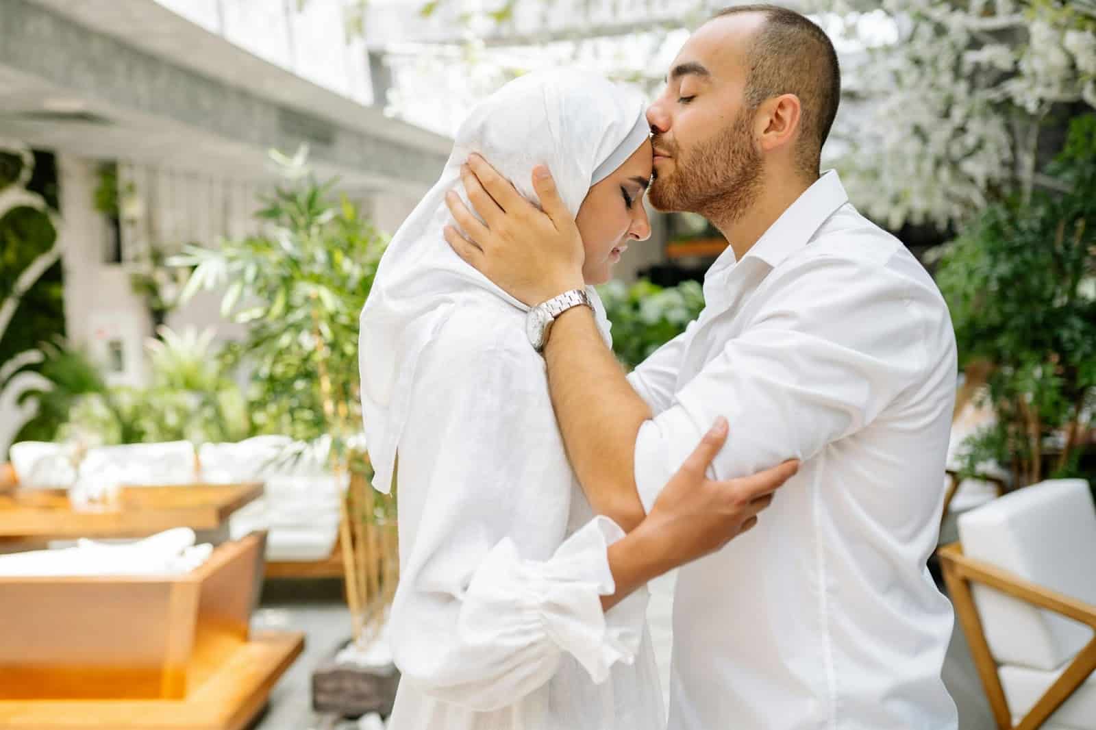 A man kissing a woman’s forehead.