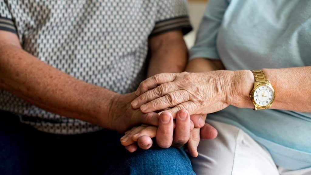 A close-up of elderly hands gently resting on each other.