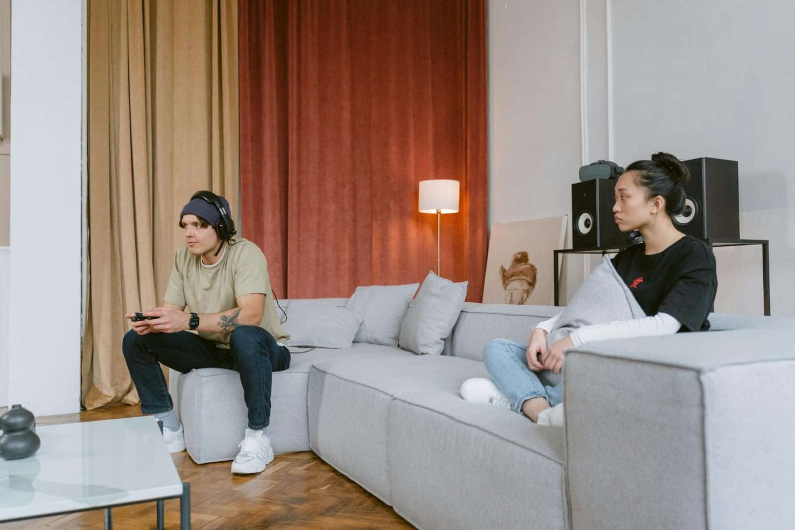 A man busy playing video games and a woman just watching him.
