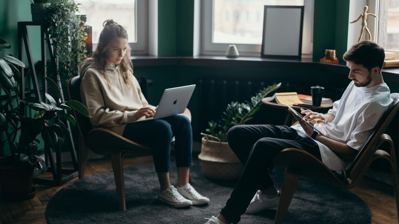 A man and woman busy with their own laptop.
