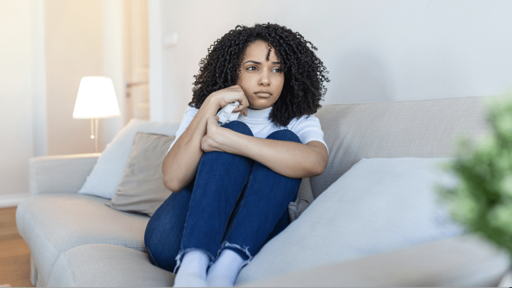 A woman looking sad at home