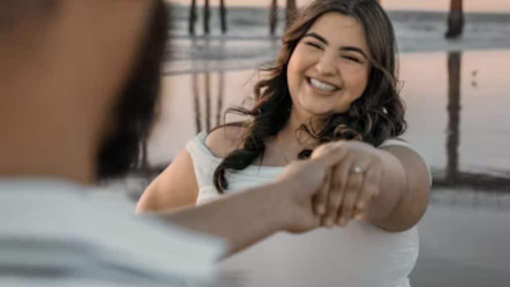 Woman with natural curves standing confidently, husband holding her hand