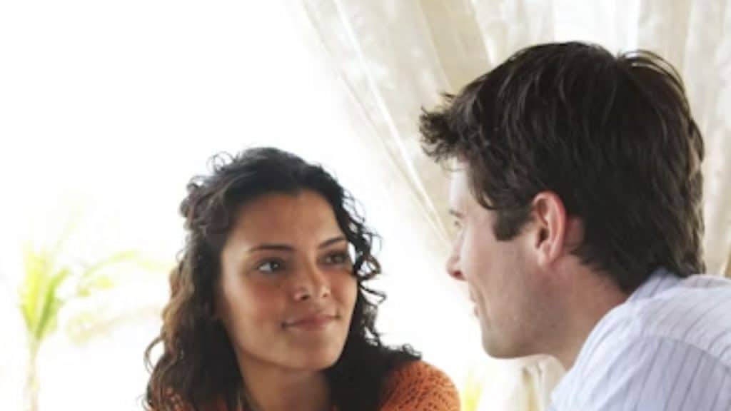 Woman speaking while smiling, husband listening closely