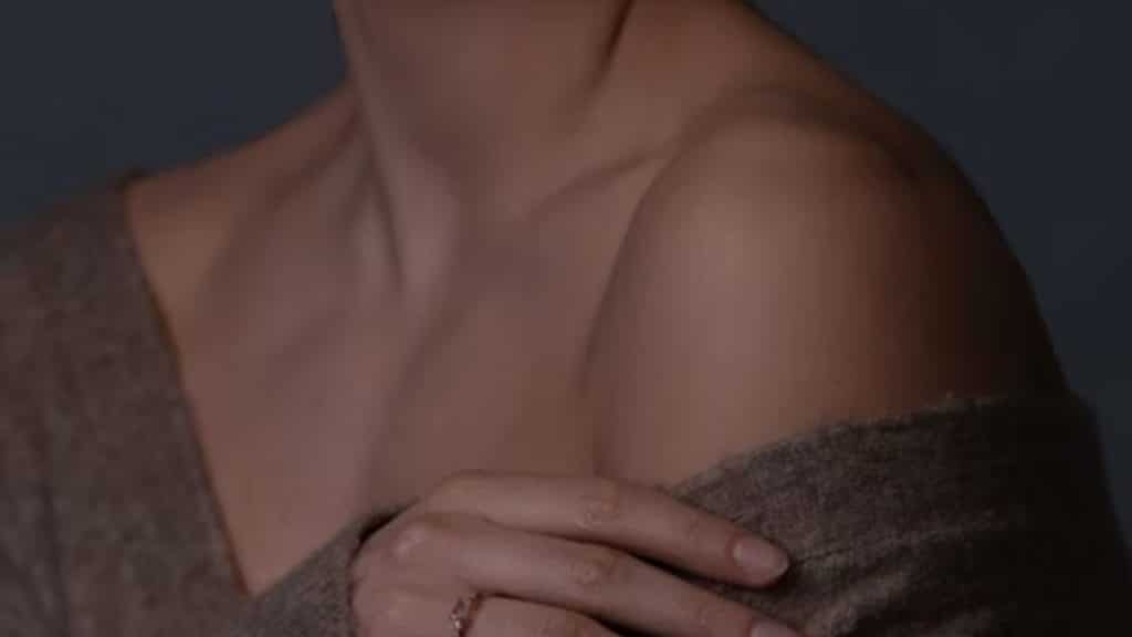 Woman showing small scar on arm, husband tracing it gently