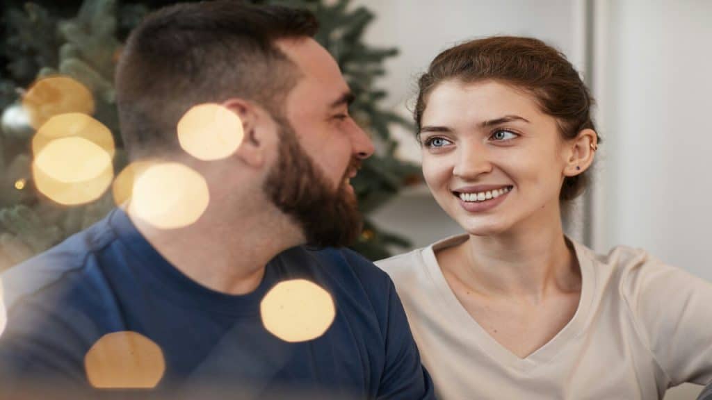 A couple looking at each other at Christmas