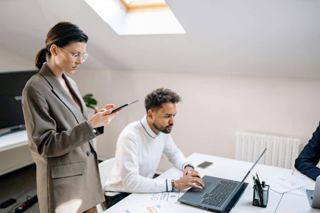 A woman waiting for a man and a man busy with his laptop