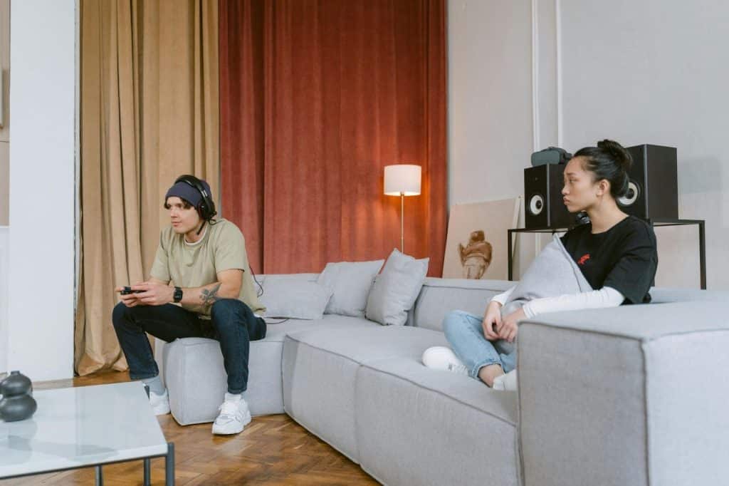 A man playing a game and a woman just watching him