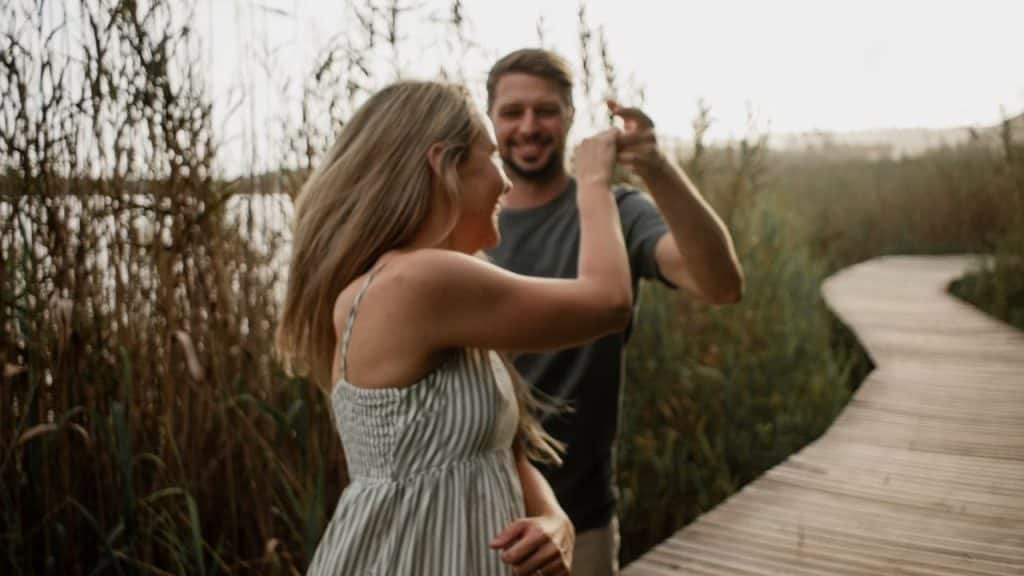 A man looking relieved while his partner surprises him with a proposal