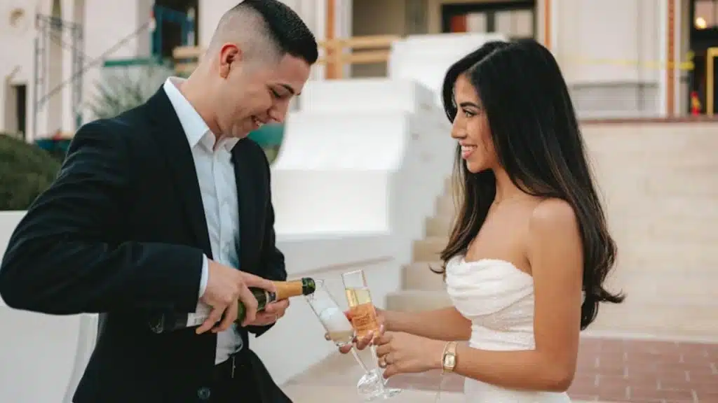 A couple celebrating their engagement with champagne and smiles