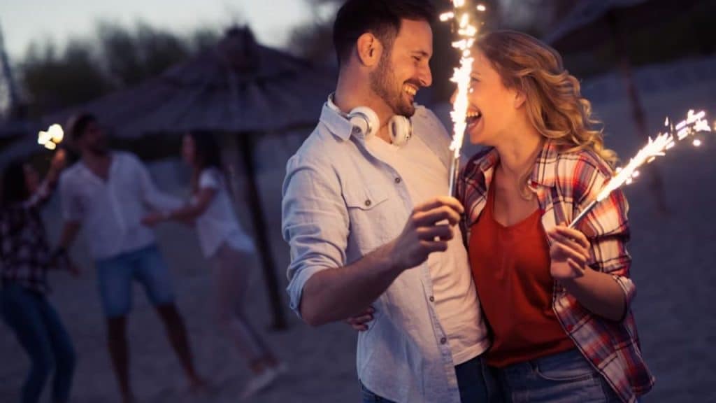 A couple celebrating with sparklers enjoying and sharing engagement to friends