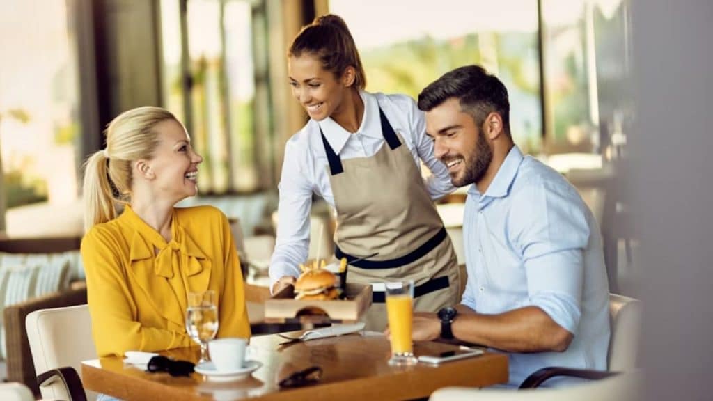 A woman smiling warmly while thanking the waitress for her service