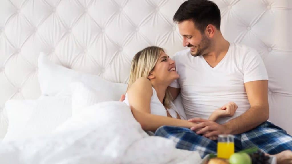 A man preparing breakfast for his wife in bed