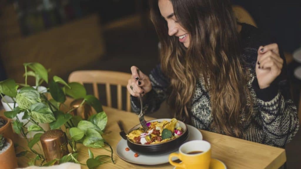 A woman enjoying a bowl of fruit and yogurt