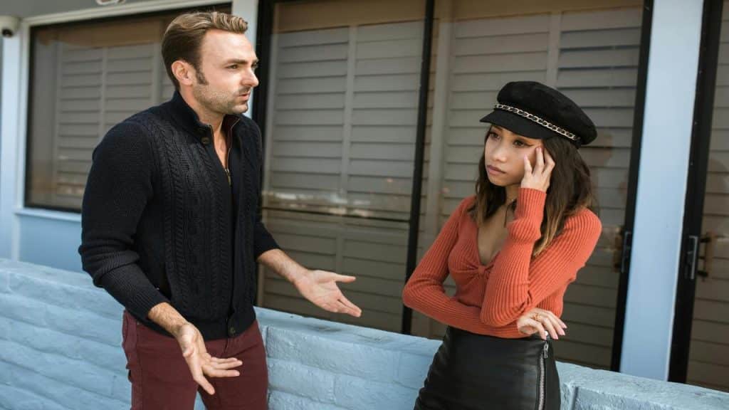 A couple arguing outdoors.