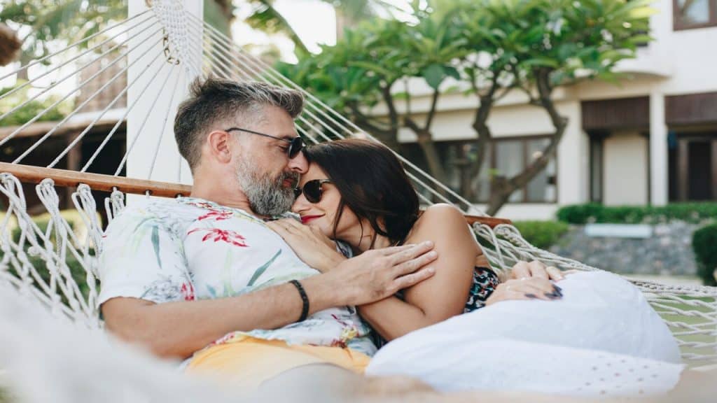 A couple cuddling on a hammock.