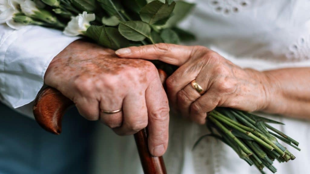 An older couple wearing their wedding rings.