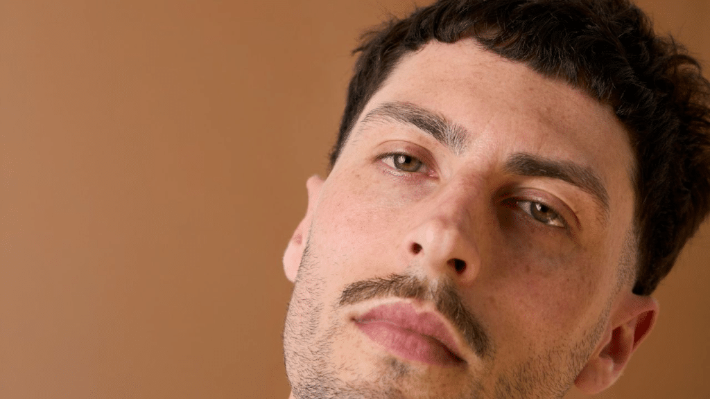 A close-up of a man's face, his head tilted.