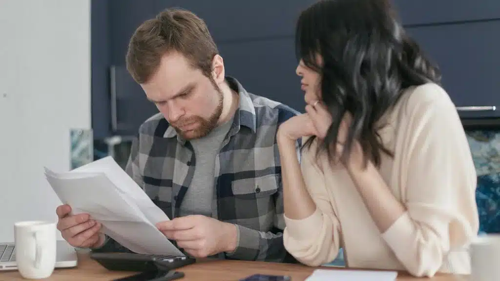 A man and a woman reviewing documents together at a table.