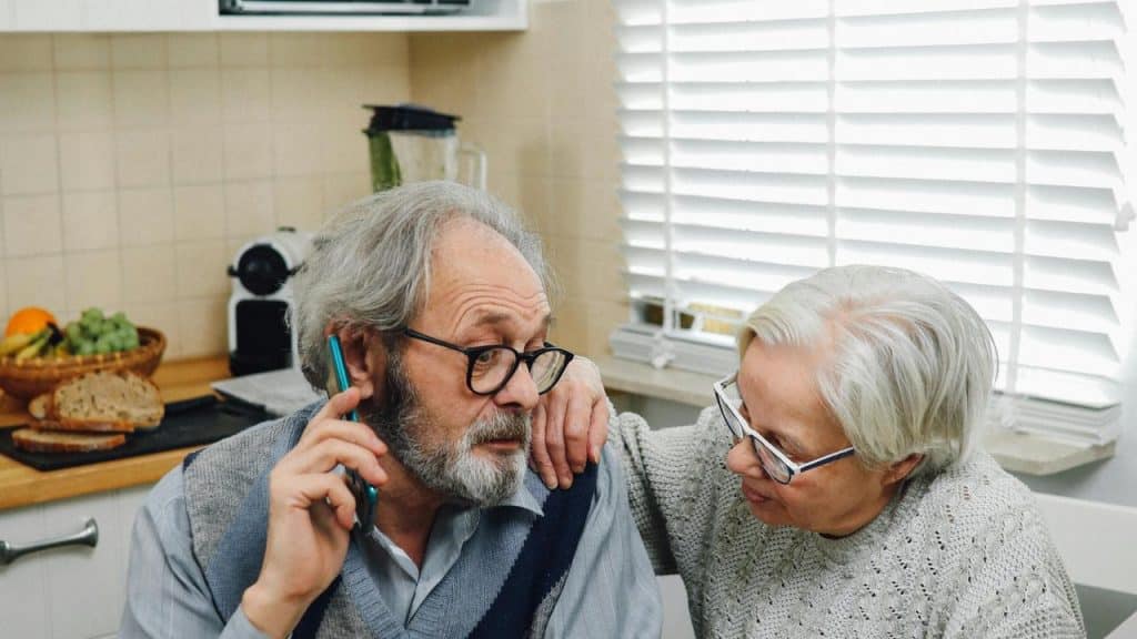 A senior couple holding hands at a table.