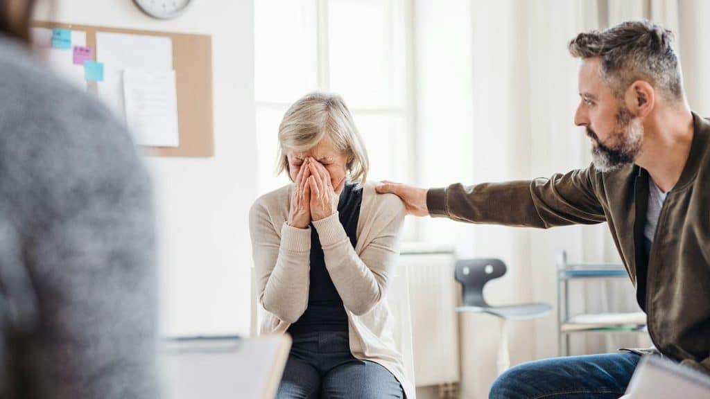 A man comforting a crying woman.