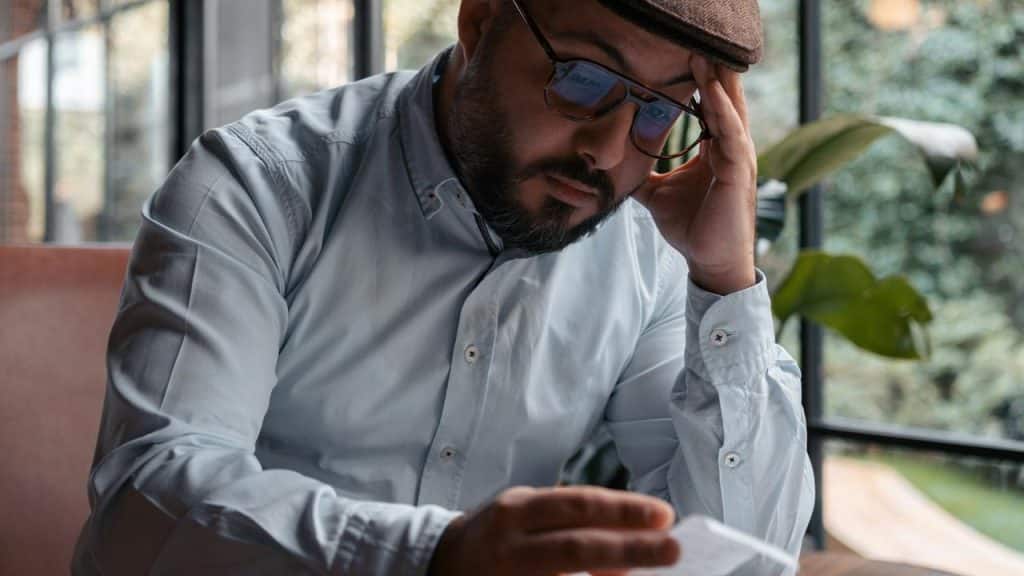 A man wearing glasses reading a document.