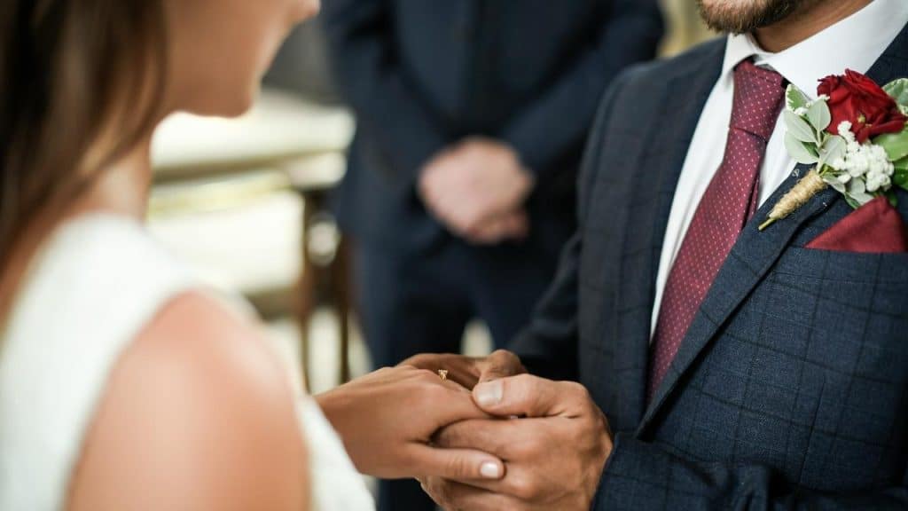 A bride and groom exchanging rings during their wedding ceremony.