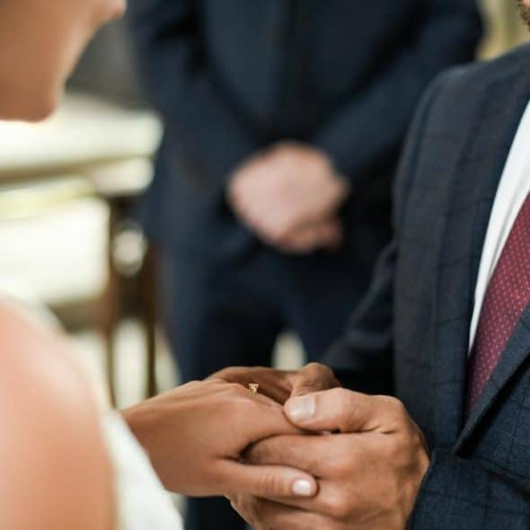 A bride and groom exchanging rings during their wedding ceremony.