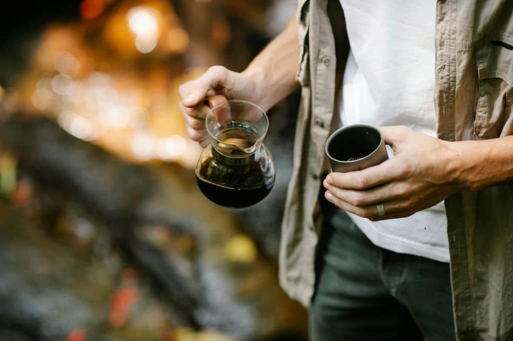 A man holding a mug and a coffee