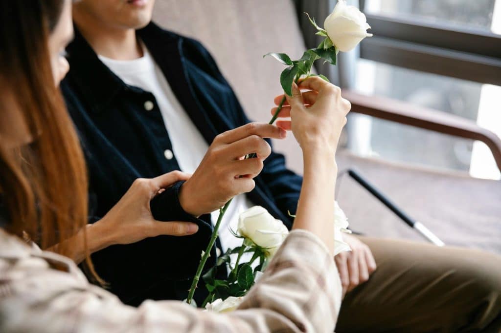 A man giving a woman a flower day by day